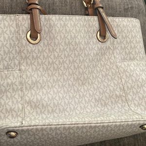 Cream monogram Michael Kors tote with side pockets.